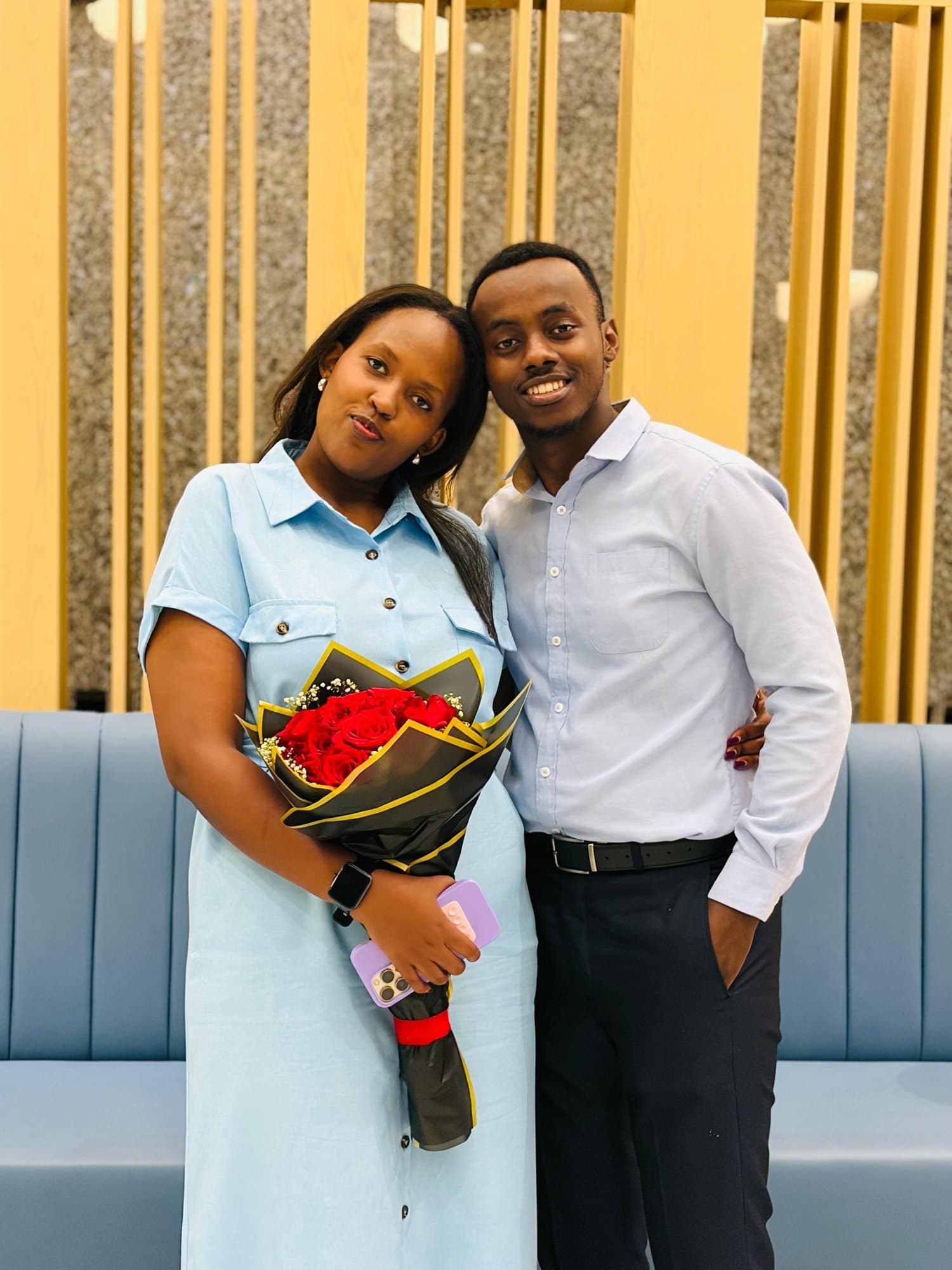 Alisiane holding a bouquet of red roses beside Tristan