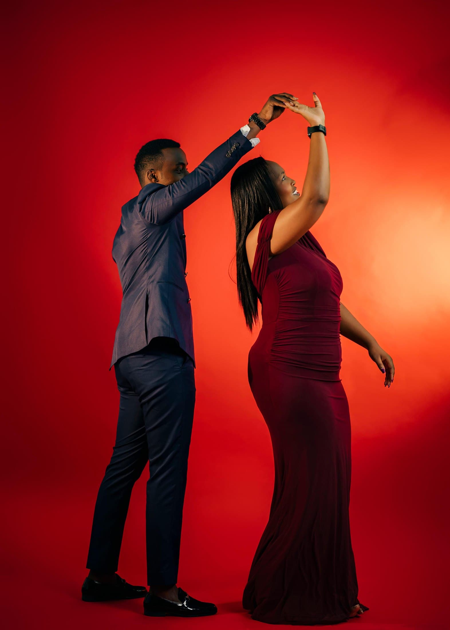 Tristan twirling Alisiane in an elegant dance against a red backdrop