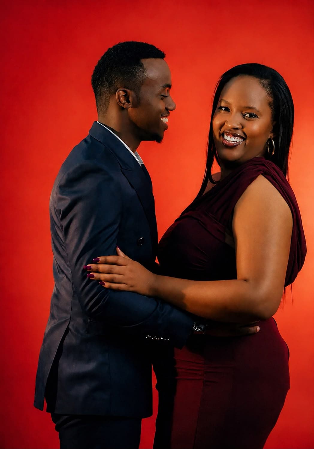 Alisiane and Tristan embracing against a warm red backdrop