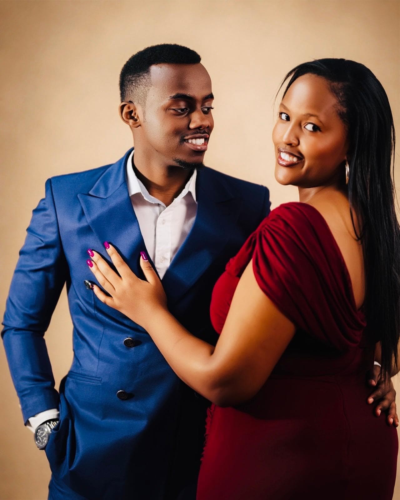 Alisiane and Tristan smiling at each other against a warm golden backdrop